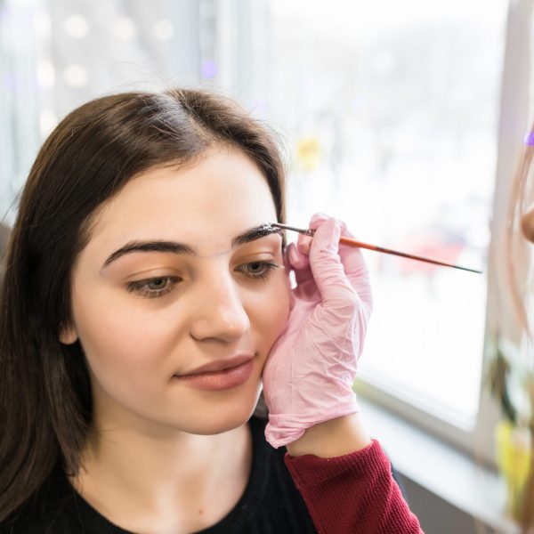 model is doing eyebrow painting procedure